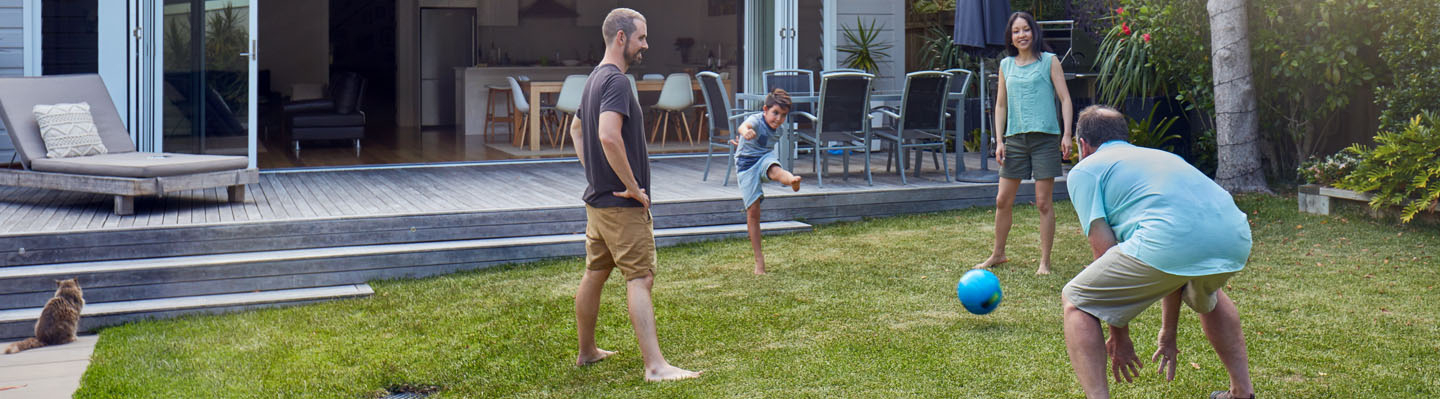 A family playing kickball in the backyard
