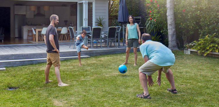 A family playing kickball in the backyard